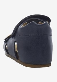 Marinblå lädersandaler med öppen bakdel, utskärningsdesign på sidorna och platt sula. Har en mjuk fotbädd för komfort.