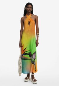 Sundress featuring an orange to green gradient, keyhole neckline, and vivid print of a bird and tropical plant, made from lightweight fabric.