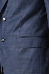 Blazer de cuadros en tonos azul marino, fabricado en un tejido texturizado, que presenta un único bolsillo en el pecho, dos botones y un ligero brillo en el material.
