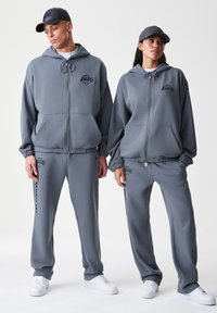 Felpe con cappuccio grigie con zip e pantaloni tuta abbinati, con logo dei Lakers. Realizzati in tessuto morbido, con cappucci regolabili tramite coulisse e polsini elasticizzati.