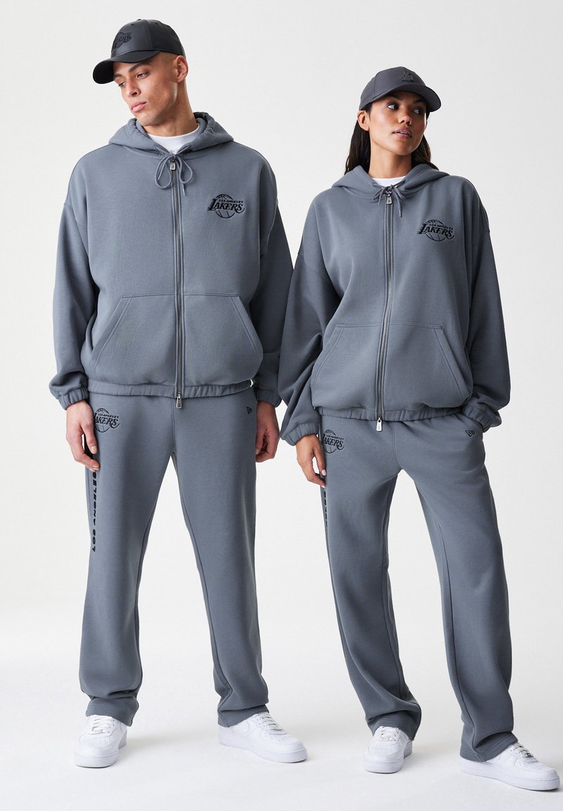 Felpe con cappuccio grigie con zip e pantaloni tuta abbinati, con logo dei Lakers. Realizzati in tessuto morbido, con cappucci regolabili tramite coulisse e polsini elasticizzati.