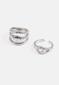 Sølv stablede ringe med glatte og teksturerede overflader, accenter af små krystaller, med stjernen motiver på en af ringene.
