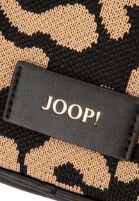 Tessuto intrecciato con motivo leopardato in beige e nero, con etichetta in pelle nera testurizzata che presenta il logo "JOOP!" in caratteri dorati.