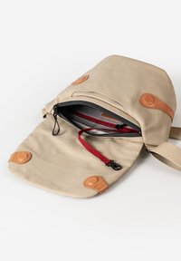 Beige Leinenschultertasche mit Lederakzenten, Klappenöffnung, rotem Reißverschlussfach im Inneren, verstellbarem Riemen und Knopfverschluss. Weiche Textur, kompaktes Design.