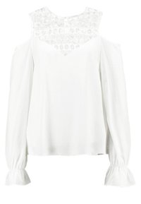 Blouse blanche avec un empiècement en dentelle texturée, design épaules dénudées, et manches longues avec poignets froncés. Tissu lisse avec une coupe décontractée.