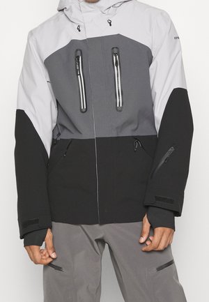 Skijakke med en kombination af lysegrå, mørkegrå og sorte paneler; to brystlommer med lynlås, justerbare manchetter og tekstureret stof.