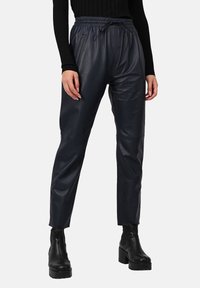 Pantalons fuselés noirs en simili cuir avec une taille élastique et un cordon de serrage, comportant des poches latérales et une texture lisse.