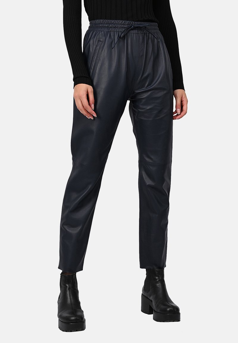 Pantalons fuselés noirs en simili cuir avec une taille élastique et un cordon de serrage, comportant des poches latérales et une texture lisse.