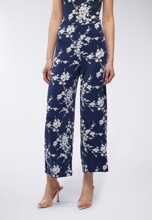 Pantaloni a gamba larga blu navy con un motivo floreale bianco, realizzati in tessuto leggero. Presentano una vestibilità comoda e un design a vita alta.