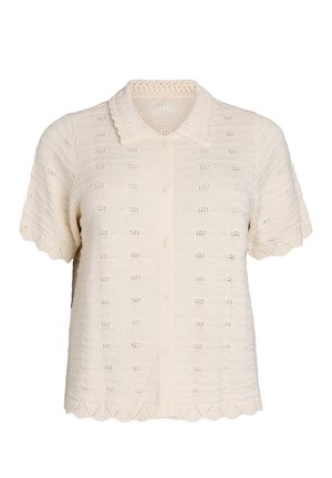 Kreemjas lühikeste varrukatega kootud topp, millel on laineline krae ja ääre, eest nööbitav ning kogu kangas on õrna aasa mustriga.