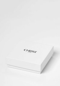 Weißer rechteckiger Kasten mit einer glatten Oberfläche, der oben ein schwarzes Logo mit dem Text "CHRIST seit 1863" geprägt hat. Einfaches Design.