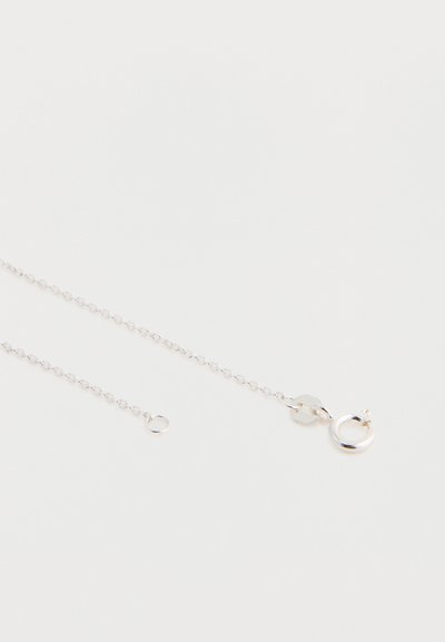 Srebrna verižica z malimi povezavami, opremljena s krožno zaponko in nastavljivo dolžino ter dodatnim obročkom za pritrjevanje.