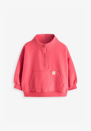 Koralinė rožinė pusiau užtraukiama džemperio su stovimu apykakliu, kengūros kišene, briaunuotais rankogaliais ir apačia, parodytas ant paprasto balto fono.