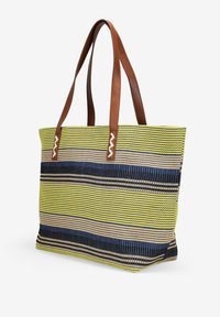 Borsa a tracolla a righe con colori giallo, blu navy e beige. Realizzata in materiale tessuto con manici in pelle marrone e decorazioni.