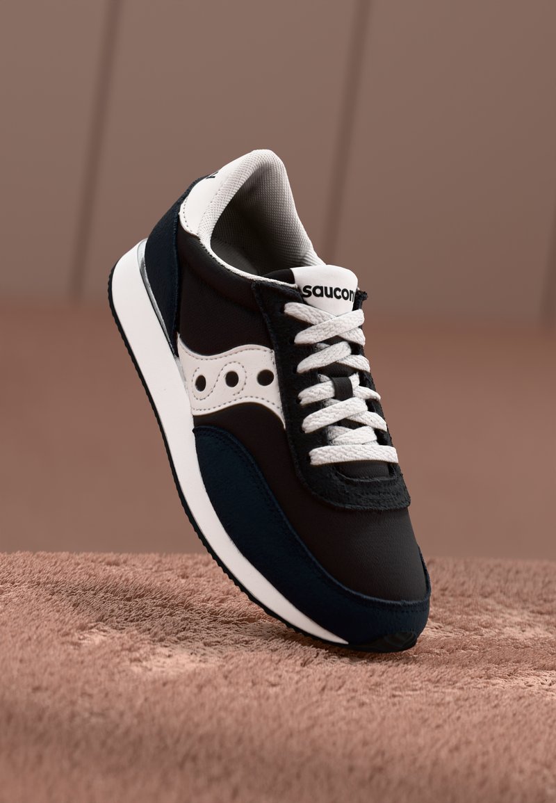 Čierne a námornícke tenisky s bielymi akcentmi, textúrované materiály, zaoblený špička a biele šnúrky. Na jazyku sa nachádza logo Saucony.
