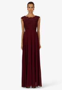 Burgunderfarbenes Abendkleid mit einem floralen Spitzenoberteil, kurzen Cap Sleeves und einem fließenden Rock. Glatte Textur mit einer taillierten Taille.