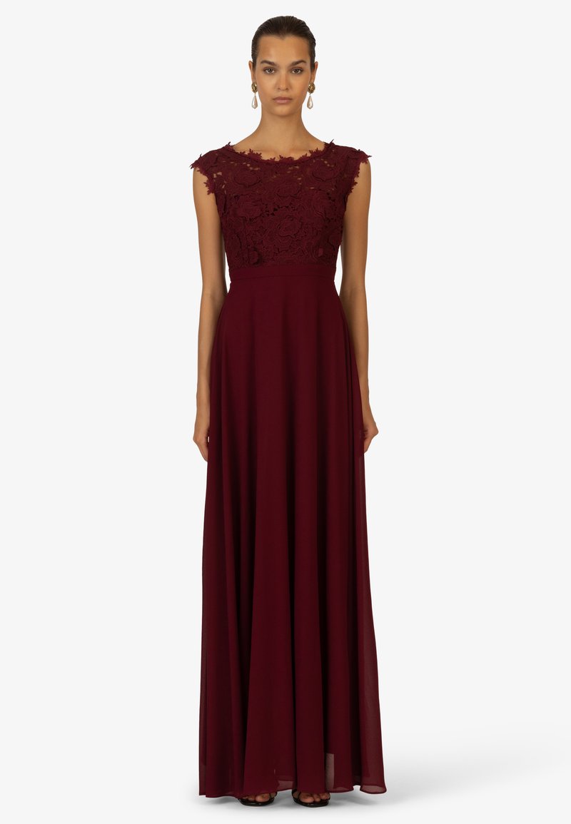 Burgunderfarbenes Abendkleid mit einem floralen Spitzenoberteil, kurzen Cap Sleeves und einem fließenden Rock. Glatte Textur mit einer taillierten Taille.