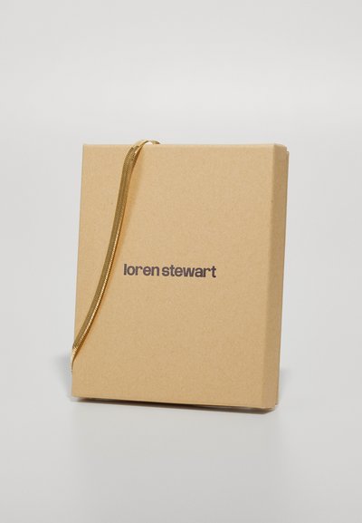 Cutie din hârtie kraft maro cu o panglică aurie; are inscripționat "loren stewart" în maro închis pe față. Formă pătrată cu textură netedă.