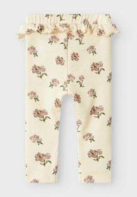 Leggings jaunes avec une texture côtelée, ornées d'un motif floral de fleurs roses et bleues, surmontées d'une taille froncée.