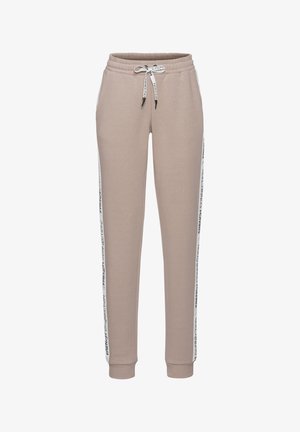 Beige katoenen joggers met elastische tailleband, verstelbare trekkoord en zijstrepen met tekst in zwart en wit.