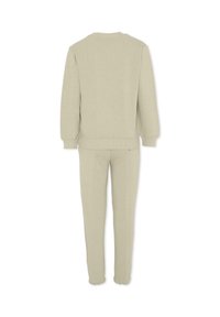Ensemble sweat-shirt et joggers en coton beige, avec des manches longues, des poignets côtelés et une taille élastiquée, présenté de dos.