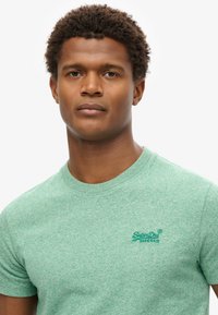 Green heathered t-shirt in a soft cotton blend; features a round neckline and embroidered "SuperDry" logo on the left chest.