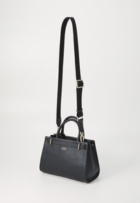 Sort læderhåndtaske med pebble-lignende struktur, to håndtag øverst, aftagelig rem, guldsmykker og trekantet form. Logo detalje på fronten.