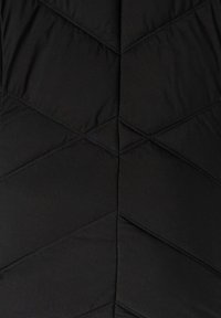 Zwarte gewatteerde vest met een quiltontwerp en diagonale stiksels. Gemaakt van lichtgewicht, waterafstotende stof met een gladde textuur.