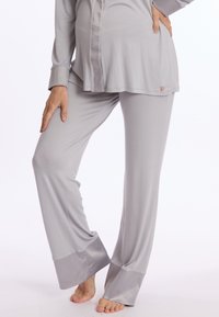 Ensemble de pyjama gris comprenant un haut à manches longues avec un devant boutonné et un pantalon assorti avec des poignets en satin. Tissu doux et fluide pour un confort optimal.