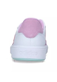 White sneaker with pink suede heel tab and pink accents. Features a flat sole with a light blue translucent layer and embossed logo.