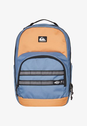 Un sac à dos Quiksilver bicolore bleu et orange avec une poche zippée à l'avant, des tirettes de fermeture éclair noires et le logo de la marque en haut au centre.