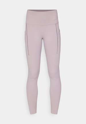Leggings i lys mauve, laget av stretchy stoff, med høy midje og sidelommer med sømdetaljer.