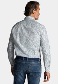 Hemd met lange mouwen van blauw en wit gestreepte stof, voorzien van een standaard kraag en knoopmanchetten, gecombineerd met blauwe denim jeans.