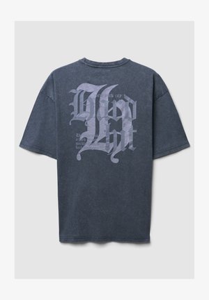 Czarny, szary t-shirt z bawełny o luźnym kroju, z dużymi białymi grafikami tekstowymi na plecach, w tym "Nowy Jork" oraz stylizowaną czcionką.