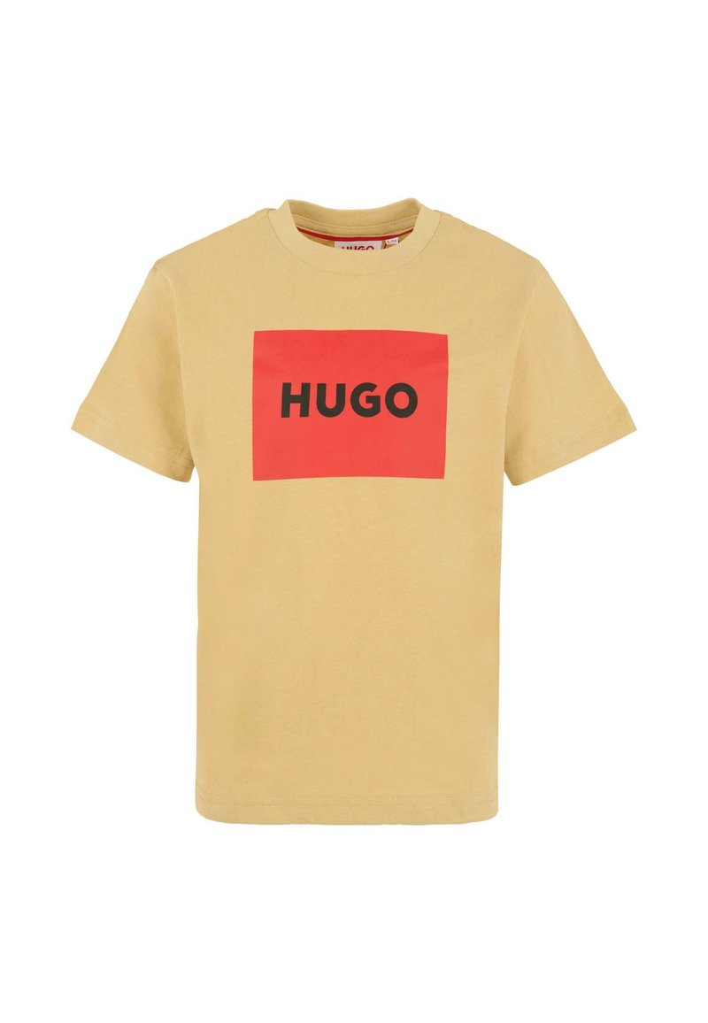 T-shirt beige à manches courtes avec un logo rectangulaire rouge affichant le mot "HUGO" en lettres noires en gras à l'avant.