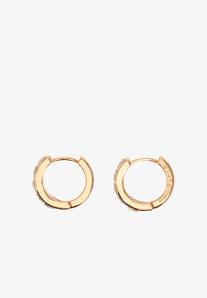 Orecchini a cerchio piccoli in tono oro con pietre trasparenti incastonate lungo i bordi esterni, chiusura semplice a scatto e incisione sottile del marchio all'interno.