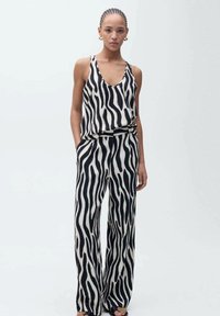 Zwart-wit gestreepte tanktop en wijdvallende broek van lichtgewicht stof, met een relaxed fit en zijzakken.