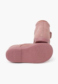 Rožiniai zomšiniai aulinukai su velcro dirželiu, apvaliu priekiu ir tekstūruotu guminio pado, kuriame yra zigzago raštas. Pagaminta Ispanijoje.