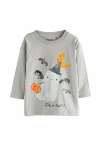 T-shirt gris à manches longues avec un graphisme de fantôme portant un chapeau noir, une lune orange et des citrouilles, avec le texte "des bonbons ou un sort ?" en dessous.