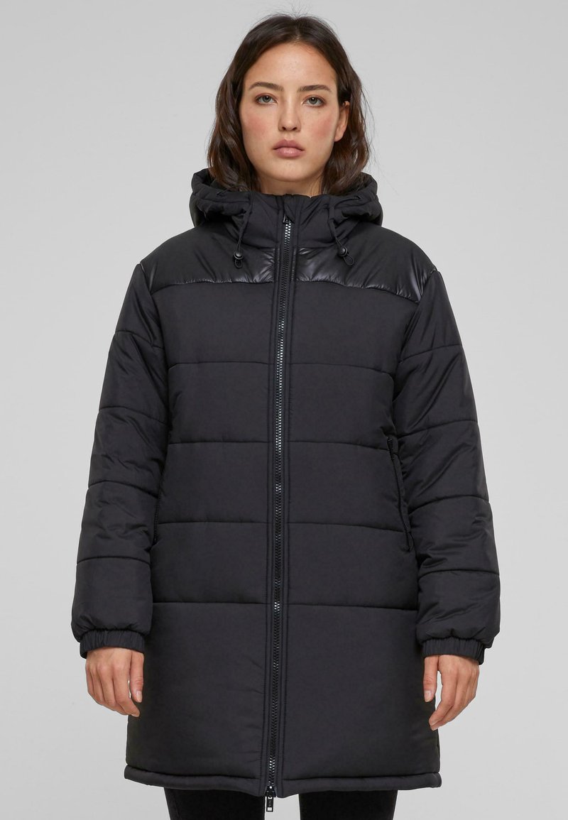 Abrigo acolchado negro con capucha, que cuenta con cierre de cremallera, puños elásticos y diseño acolchado. Fabricado en un tejido suave y ligero.