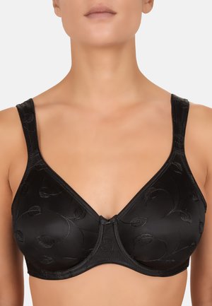 Kvinde iført en sort undertrøje med bøjle og diskrete broderede bladmotiver, vist fra hals til midt på torso mod en ensfarvet baggrund.