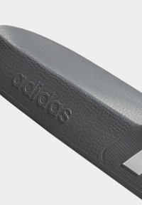 Cintura in tessuto testurizzato con logo impresso di sandali Adidas neri, con design sagomato e bordi lisci.