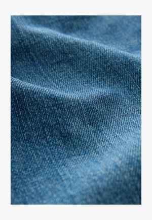 Denimtyg med en strukturerad yta i olika nyanser av blått, med en klassisk twillväv och lätt blekning för djup.