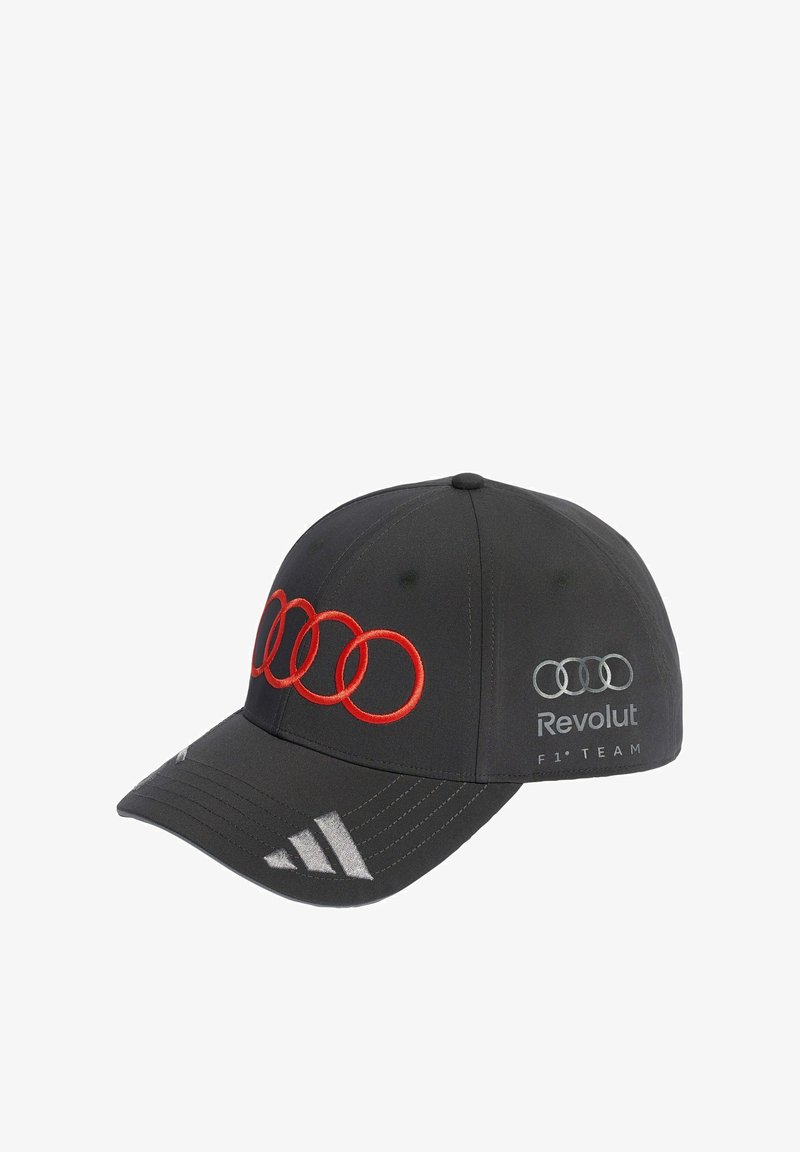 Casquette de baseball noire avec les anneaux rouges Audi sur le devant, les anneaux Audi argentés et "Revolut F1 Team" sur le côté, et le logo Adidas argenté sur la visière.