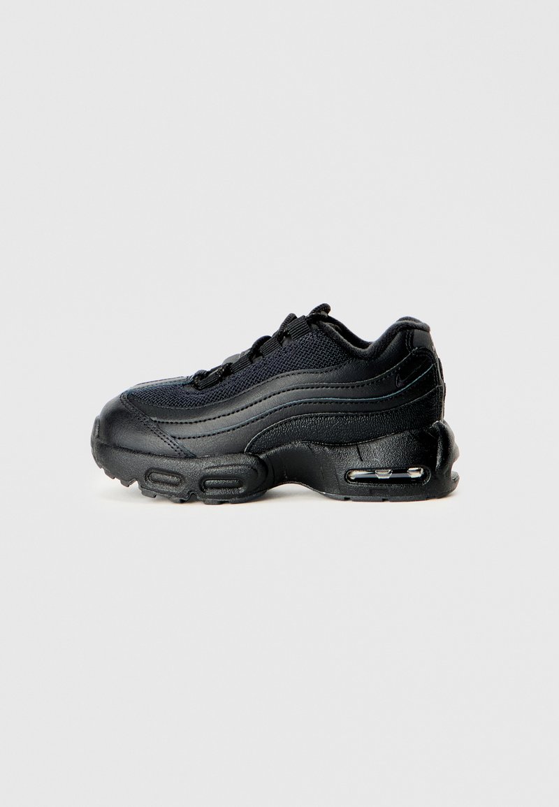 Chaussure de sport noire avec une tige en mesh et des superpositions synthétiques, bout arrondi, semelle épaisse et amorti à la talonnière.
