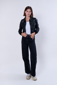 Svart läderjacka med dragkedja och framfickor, bärs över en vit T-shirt. Kombinerad med högmidjade svarta jeans och sneakers.