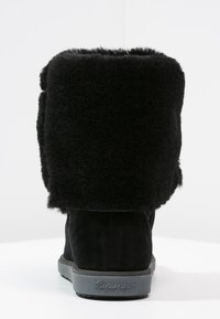 Stivaletti in suède nero con polsino spesso in pelliccia sintetica, suola in gomma e dettaglio logo discreto sul tallone. Tessuto morbido e design robusto.