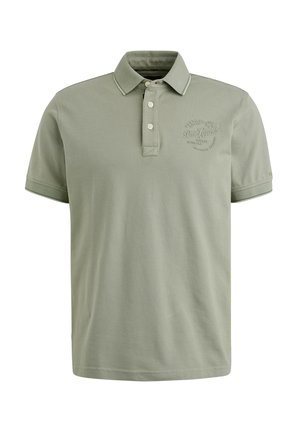 Polo skjorte i lysegrøn bomuld, med krave, tre knapper og et broderet logo på brystet. Korte ærmer med kontrast trim.