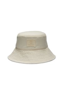Beige buckethat lavet af bomuld med en tekstureret overflade. Har et syet bånd og et kvadratisk logopatch på fronten.