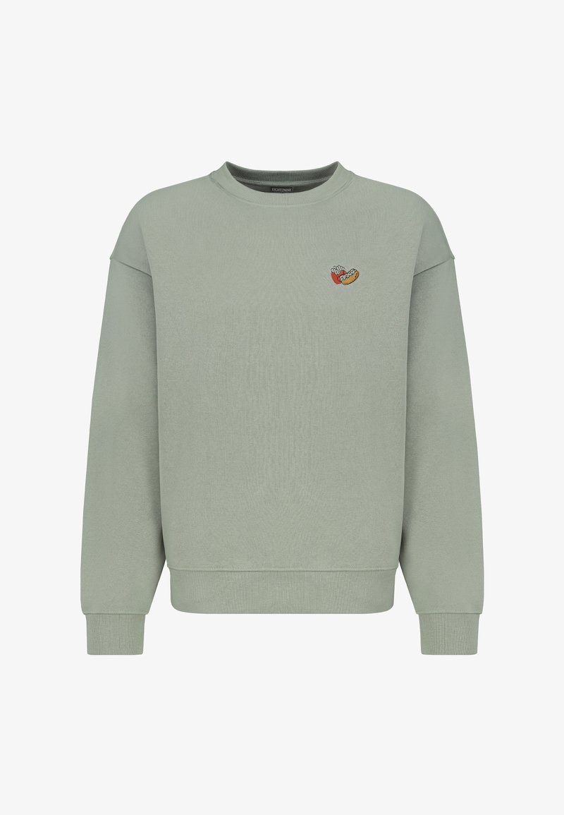 Hellgrüner Pullover aus weichem Stoff. Mit Rundhalsausschnitt und langen Ärmeln, sowie einem kleinen gestickten Design auf der Brust.